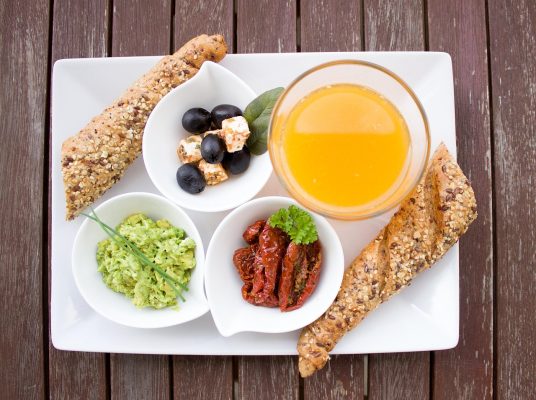 Bữa sáng lành mạnh với bánh mì nguyên cám, trái cây và nước ép trên bàn ăn