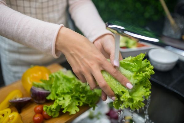 Rửa rau trong bếp để chuẩn bị bữa ăn lành mạnh cho tuần mới